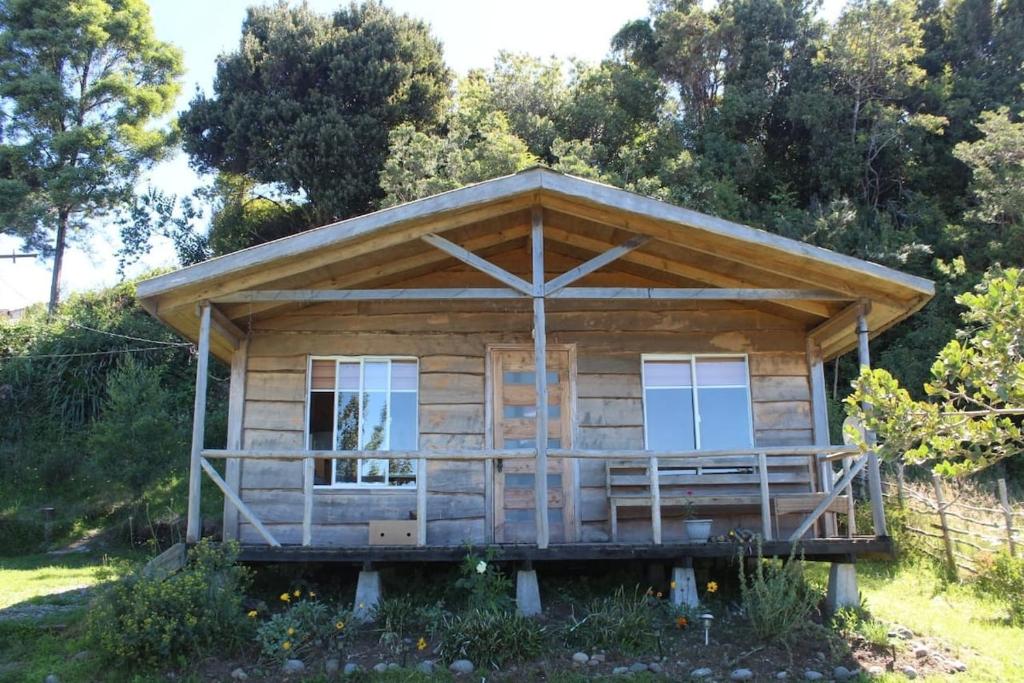 a log cabin with a porch and windows at Cabaña en Caulin 1 in Ancud