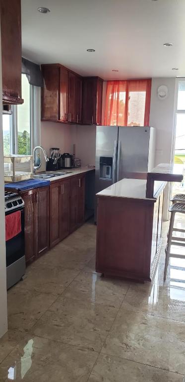 a kitchen with wooden cabinets and stainless steel appliances at Azille's Apt in Portsmouth
