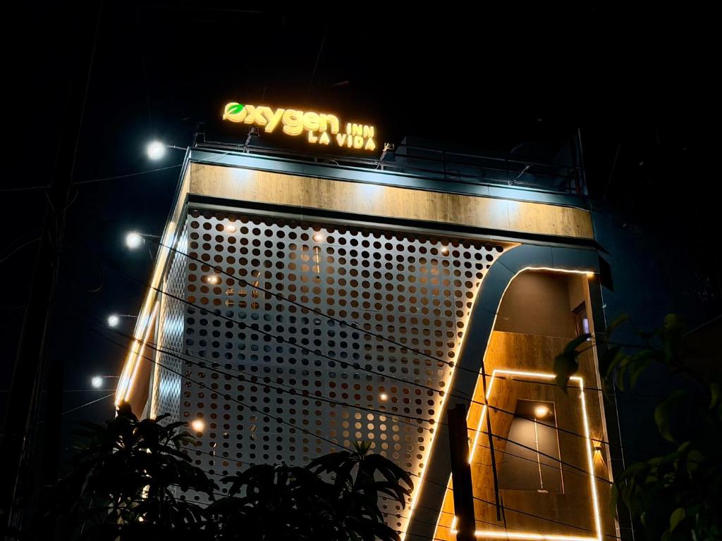 a building with a sign on top of it at night at Hotel Oxygen La Vida-Noida Sector 18 in Noida