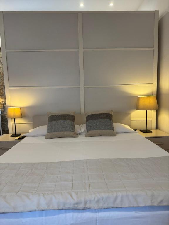 a bedroom with a large bed with two lamps at Monis Hogar in Arzachena