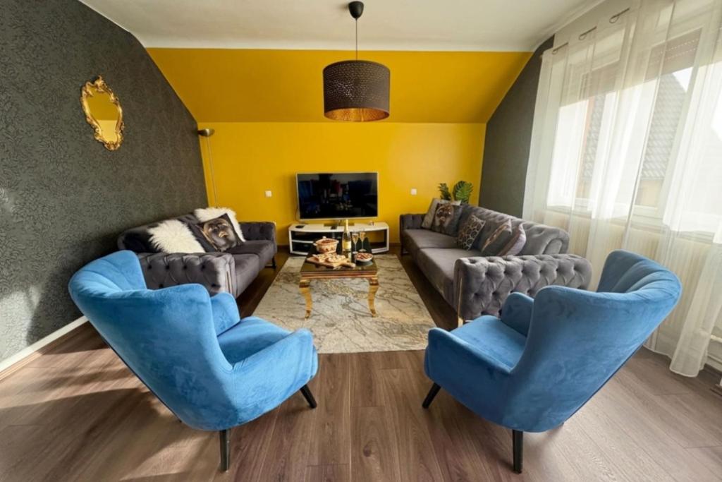 a living room with two blue chairs and a couch at Shalhome 1 Comfort at the gates of Strasbourg in Lingolsheim