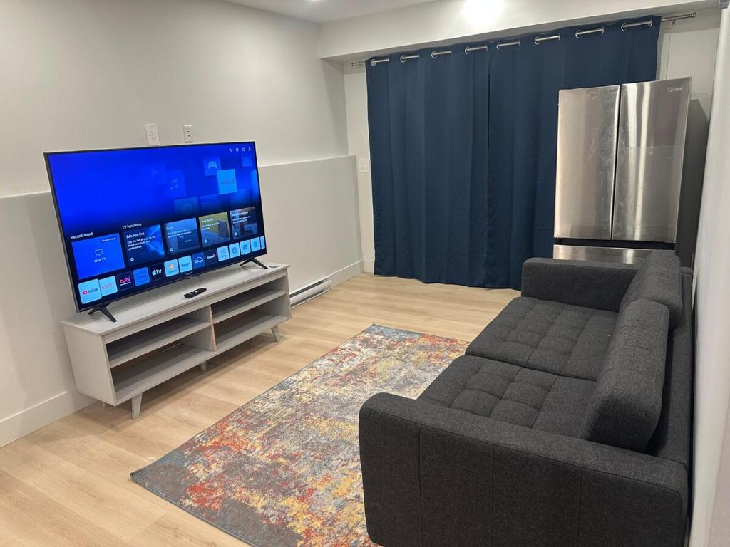 a living room with a couch and a flat screen tv at Bournas Nest in Hammonds Plains