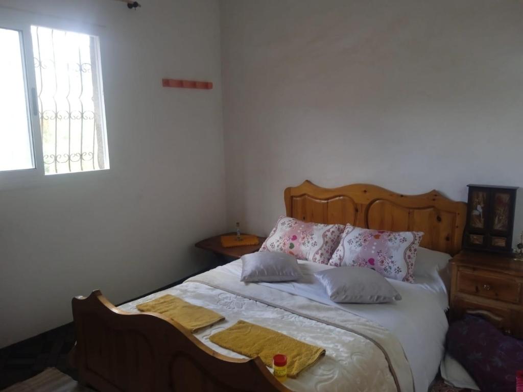 a bedroom with a bed with pillows and a window at Maison du Bonheur berbère in Aït Ougliff