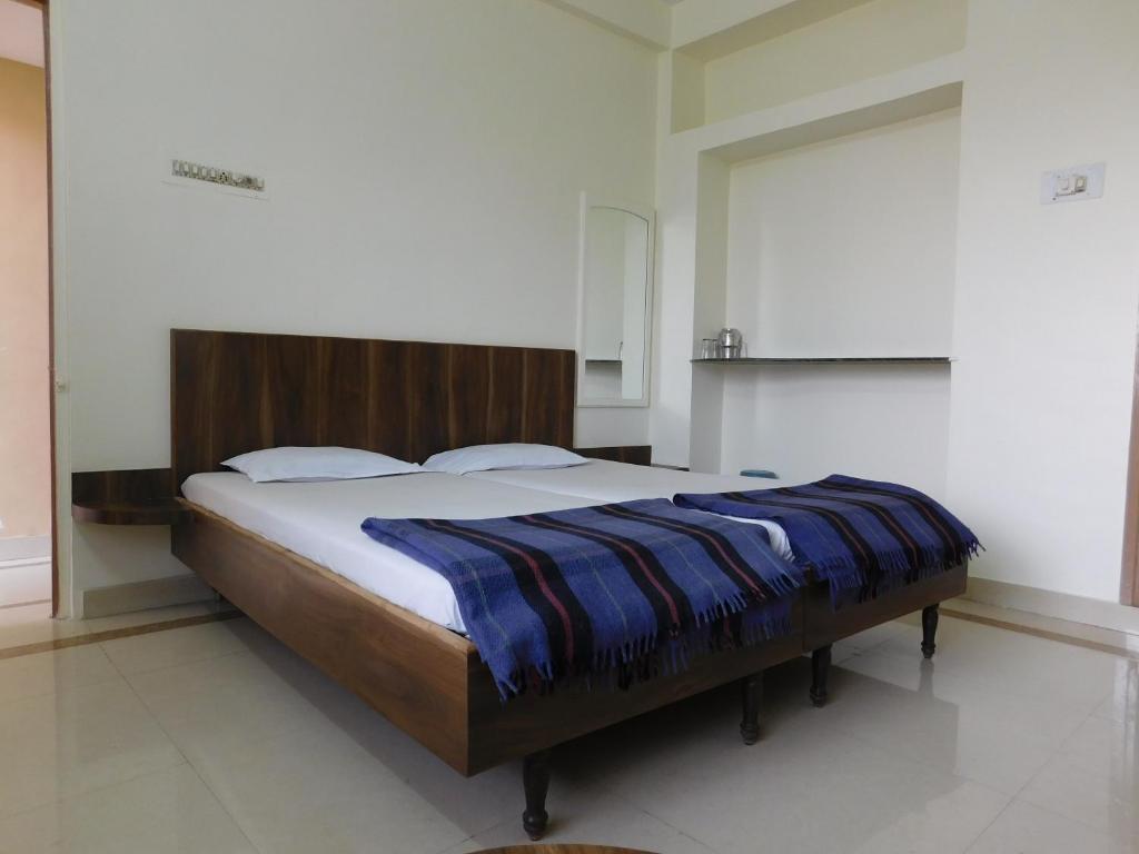 Un dormitorio con una cama con una manta azul. en Shri Gita Hotel, en Raipur