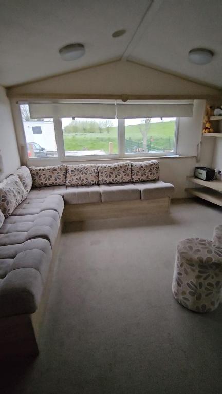 a large living room with a couch and two windows at Maison de Lucie à Tholen in Poortvliet