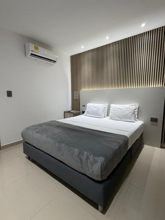 a bedroom with a large bed in a white room at Luxury Park 35 in Cali