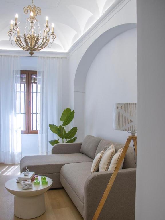 a living room with a couch and a chandelier at Jerez Centro Alojamiento Boutique in Jerez de los Caballeros