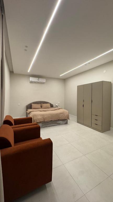 a bedroom with a bed and a couch in it at سويت بغرفتين نوم in Al Majaridah