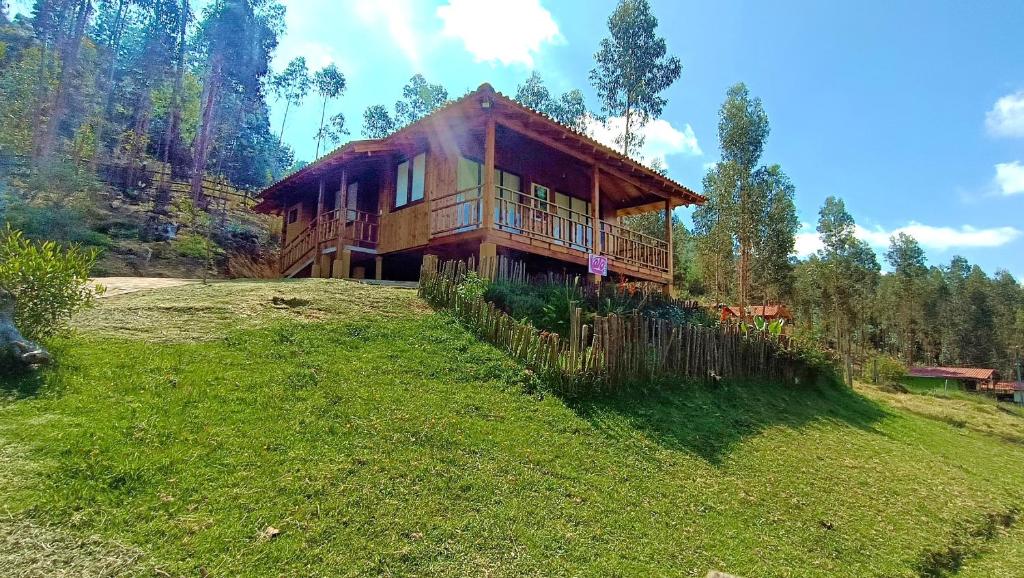 a large wooden house on a hill in a field at Cabaña Loto - Paipa in Paipa