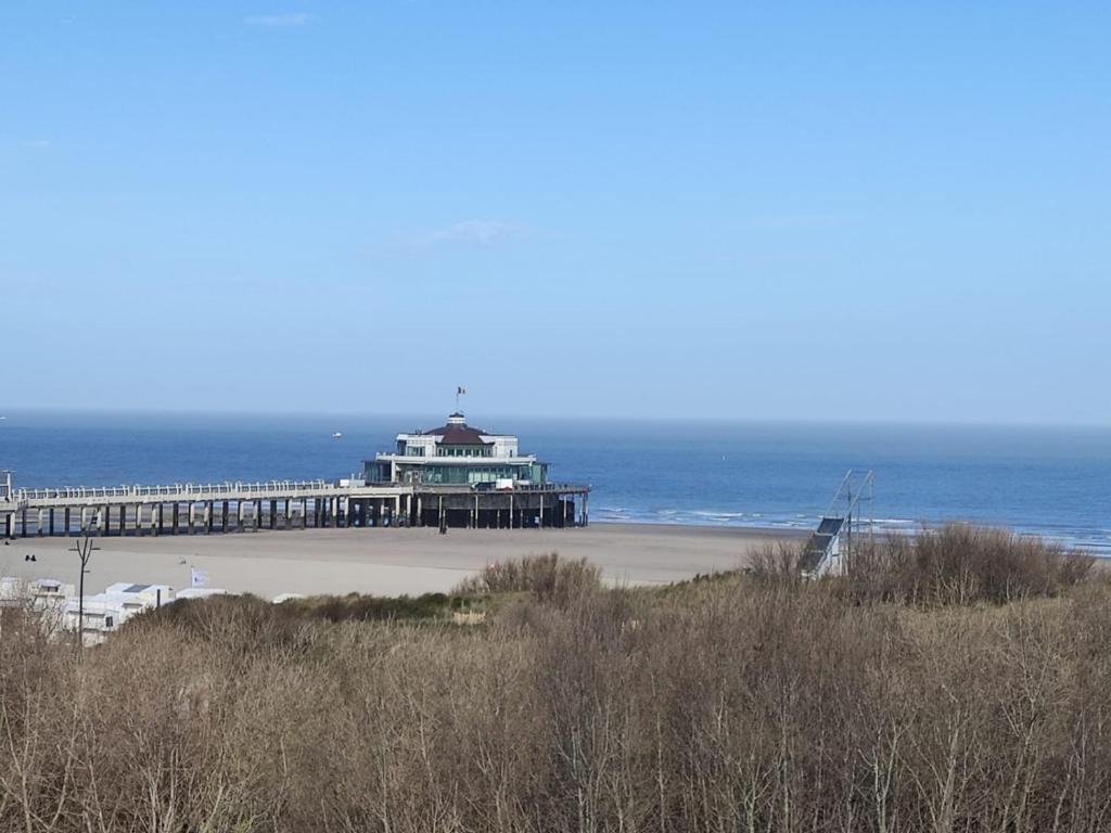 a pier on a beach with the ocean in the background at Studio met zeezicht in Blankenberge