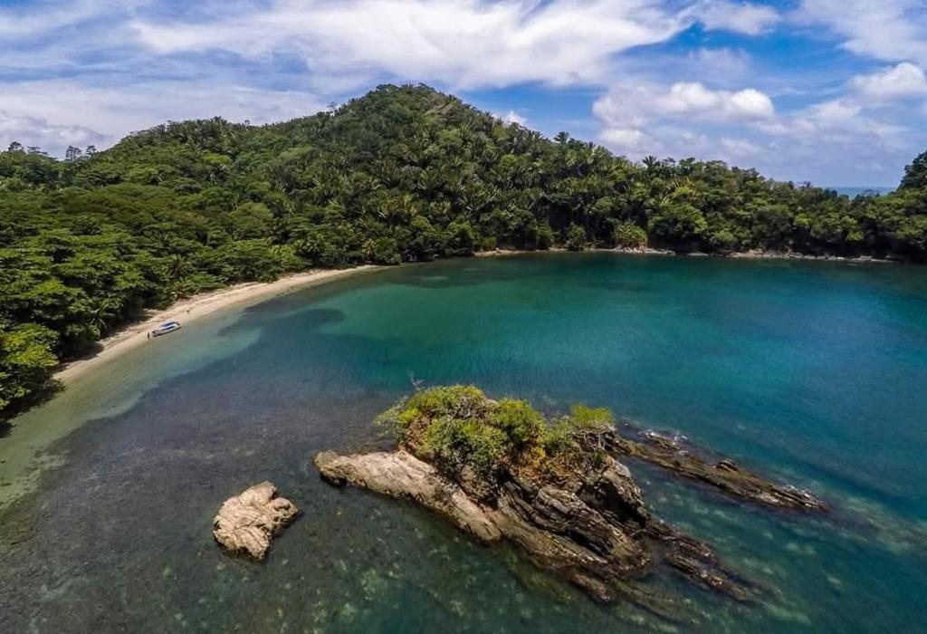 an aerial view of a beach with trees and water at Cabañas Ecológicas in Tela in Tela