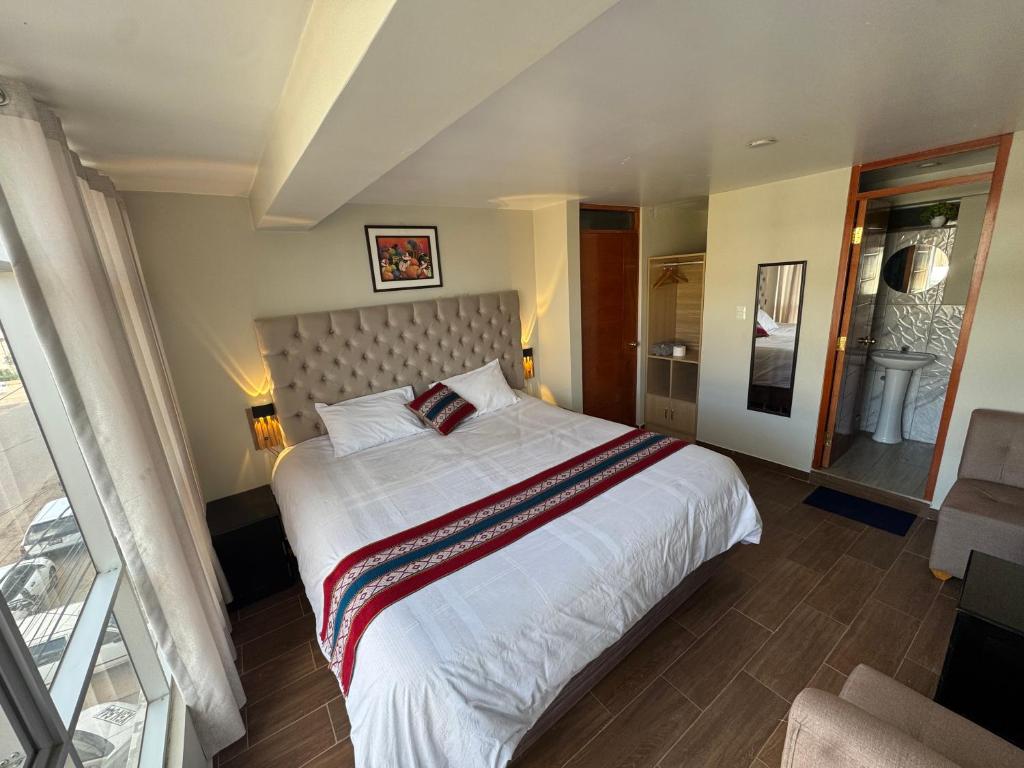 a bedroom with a large white bed in a room at Hotel Inka House Chinchero in Chincheros