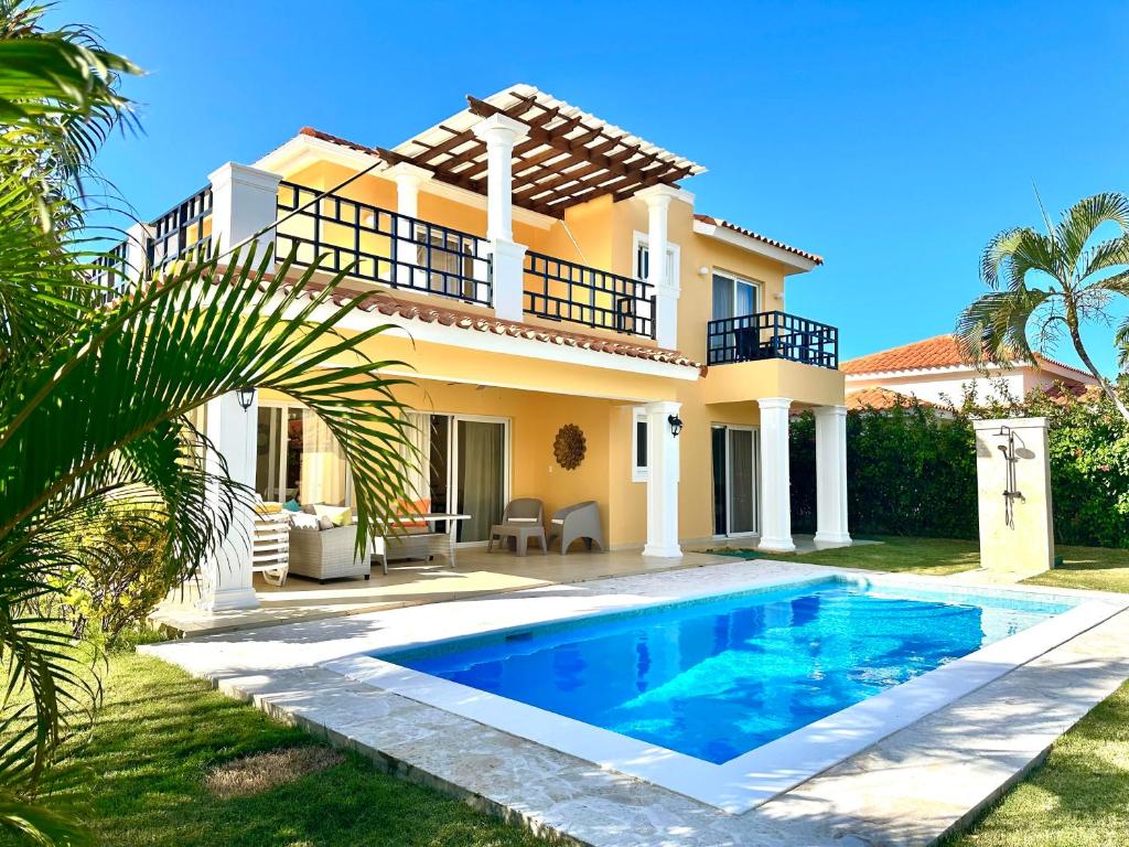 a villa with a swimming pool in front of a house at Rheia Properties - SANTA FE in Sosúa