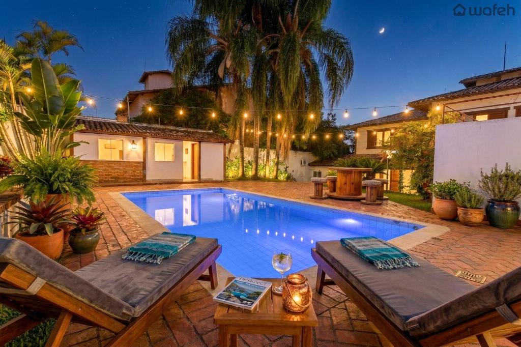 a swimming pool in the backyard of a house at Wafeh Pampulha Suítes in Belo Horizonte
