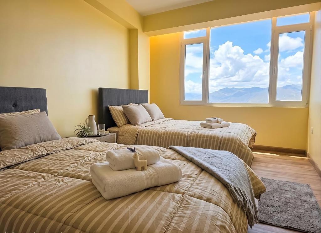 two beds in a room with two windows at Cusco Nest in Cusco