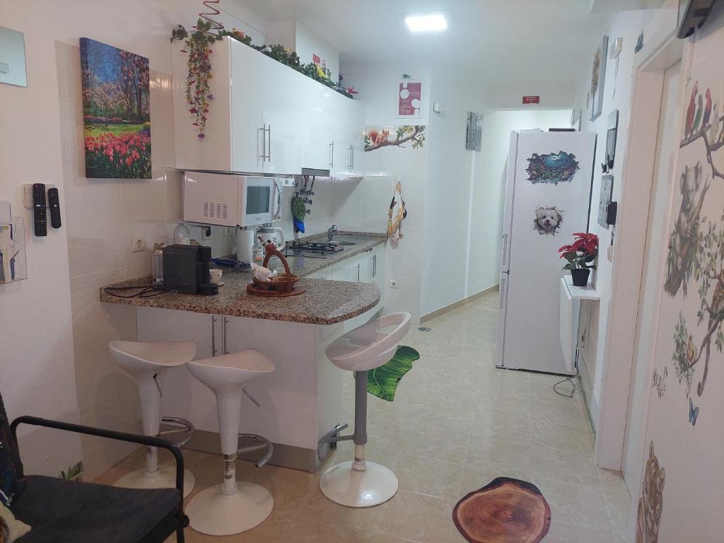 a kitchen with a counter and stools in a room at Ketchs House in Ponte de Sor