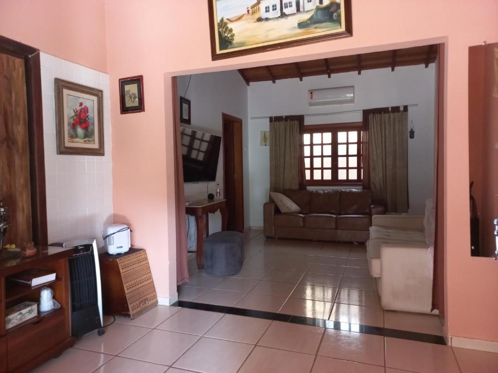a living room with a couch and a table at Chalé casa na mata Jasmim in Guararema