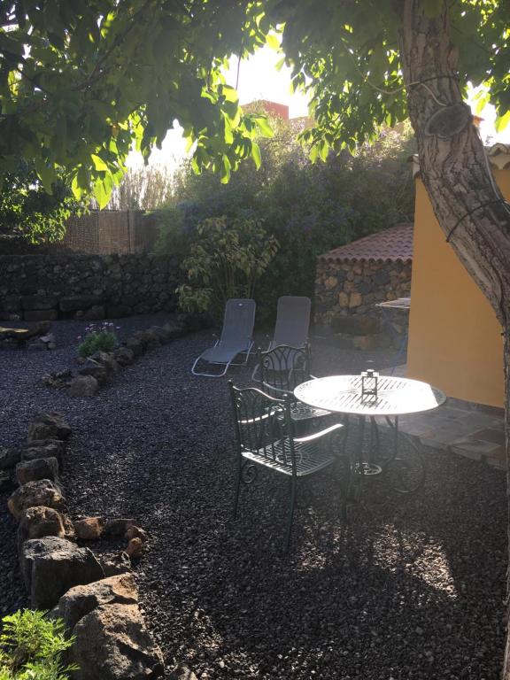 einen Tisch und Stühle unter einem Baum im Hof in der Unterkunft Casa Gusber 2 in La Rosa