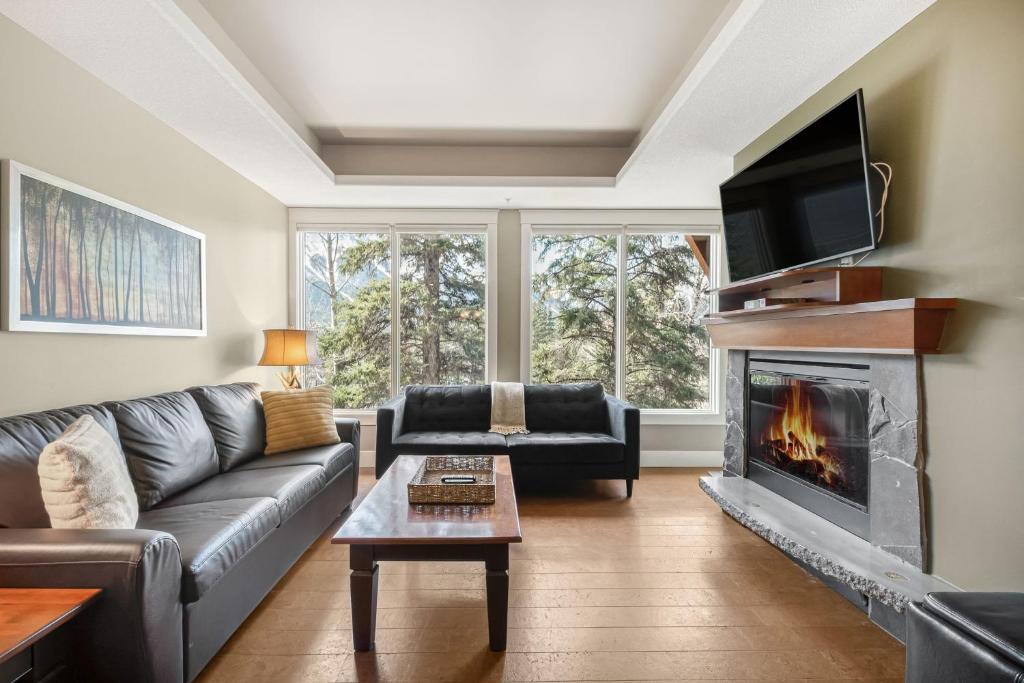 a living room with a couch and a fireplace at Star Suite -Luxurious condo with 3 fireplaces, and open Pool! in Canmore