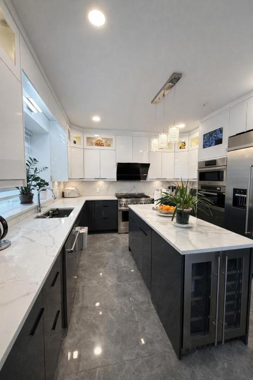 a large kitchen with white cabinets and appliances at Private Suite in a Friendly Shared Home in Vancouver