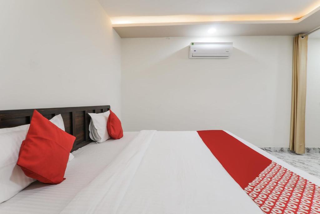 a room with a bed with red pillows at Hotel O Aastha Near Chaudhary Charan Singh International Airport in Bijnaur