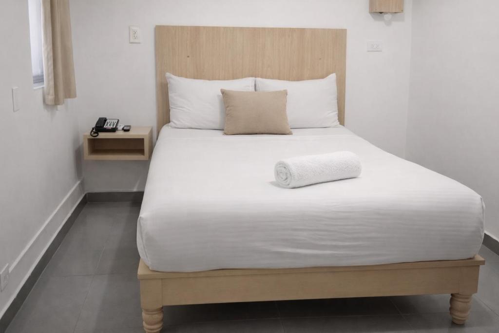 a large white bed with a pillow on it at Central Budget Room Panama in Panama City