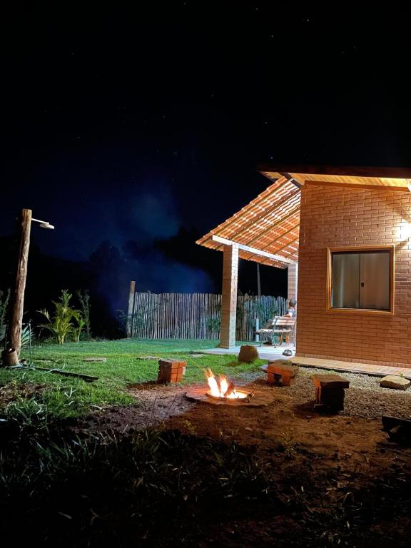 a fire pit in the yard of a house at night at Refúgio Rodreipe II in São Bento do Sapucaí