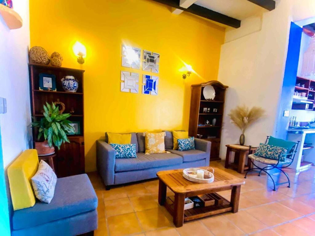 a living room with a couch and a table at Casa Adobe Balcony Breathtaking Cathedral Views in Taxco de Alarcón