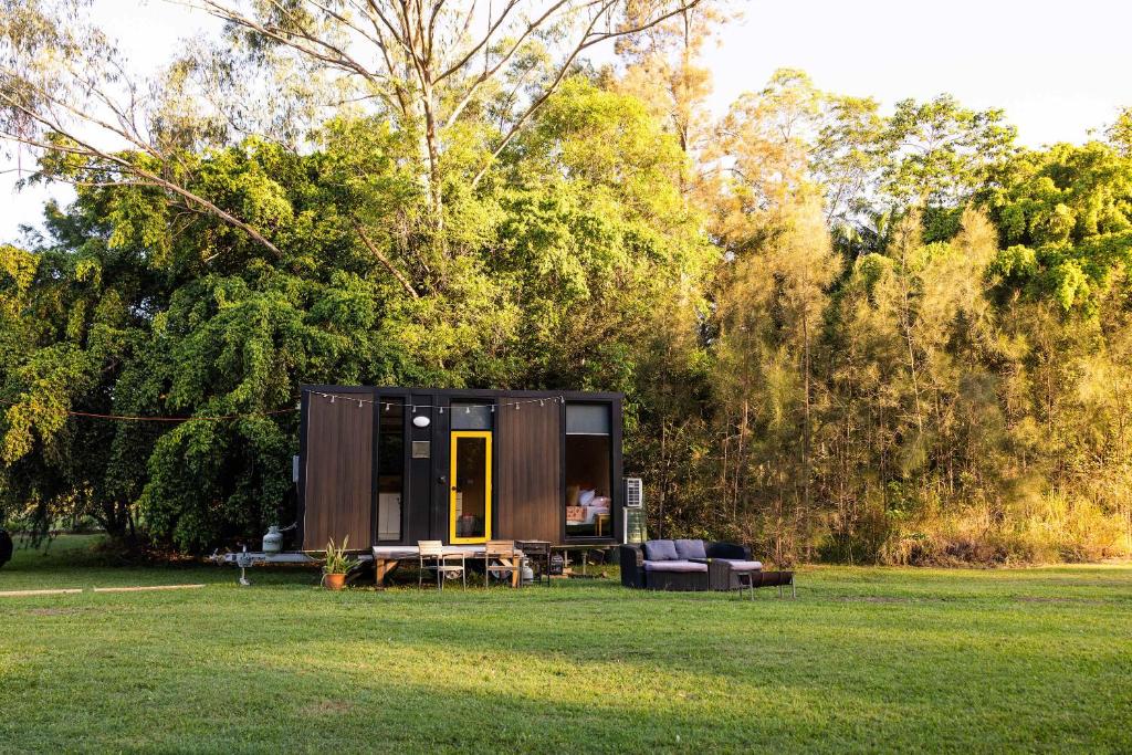 a tiny house sitting in a field in a park at Dreamseed Cabin by Tiny Away in Yandina