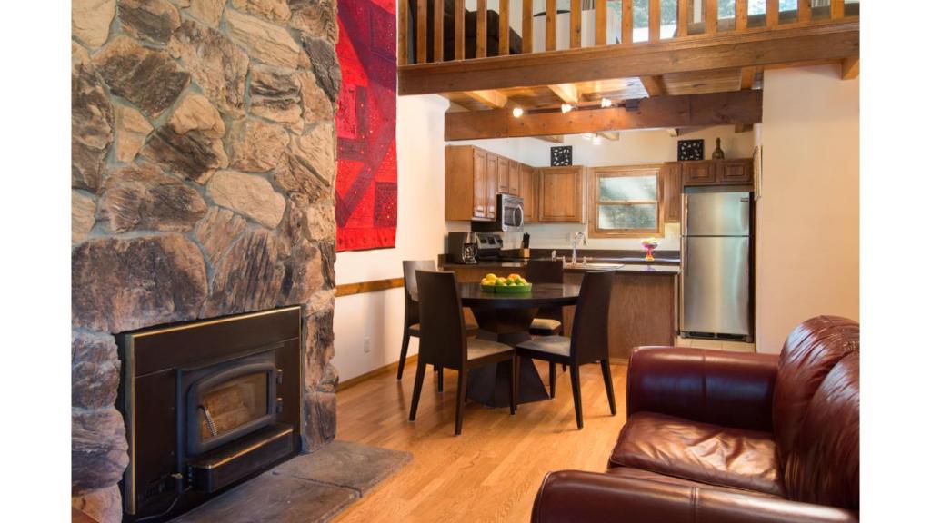 a living room with a fireplace and a kitchen at Twining 7 in Taos Ski Valley