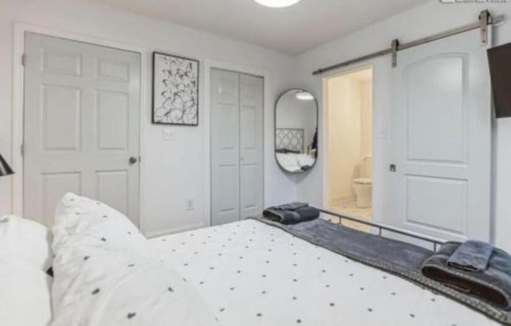 a bedroom with a white bed and a mirror at Sweet Home in Greenville