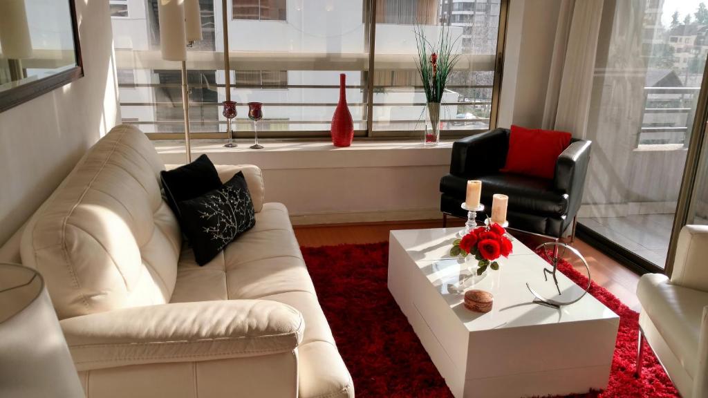 uma sala de estar com um sofá branco e uma mesa em La Gloria 30. Las Condes em Santiago