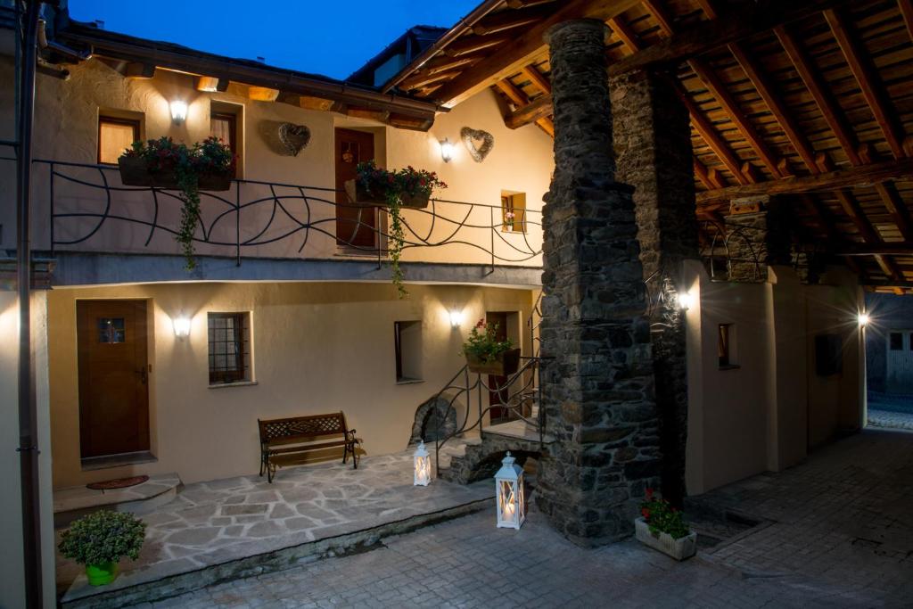 a building with a bench in a courtyard at night at La cor dé Jérémie in Montjovet