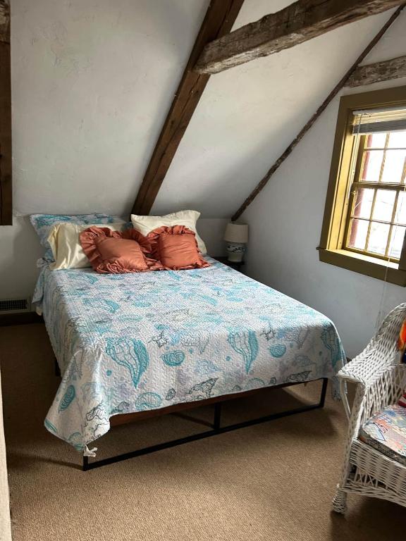 a bedroom with a bed with pillows on it at Historic Block Island Suite in New Shoreham