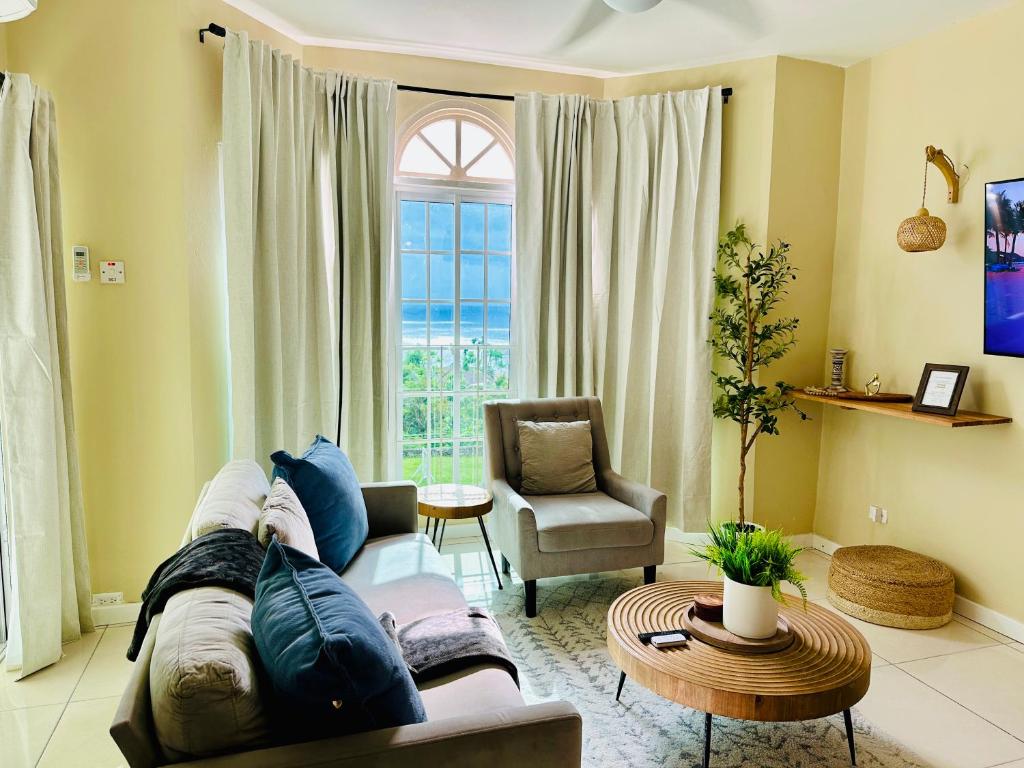 ein Wohnzimmer mit Sofa, Sessel und Fenster in der Unterkunft Falcon Views - Airport Transportation Available-Security-Gated in Montego Bay