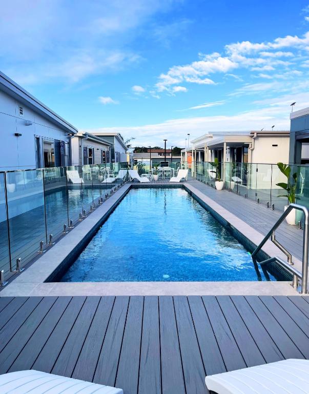 a swimming pool on a building with a wooden deck at Resort on Cedar in Windang