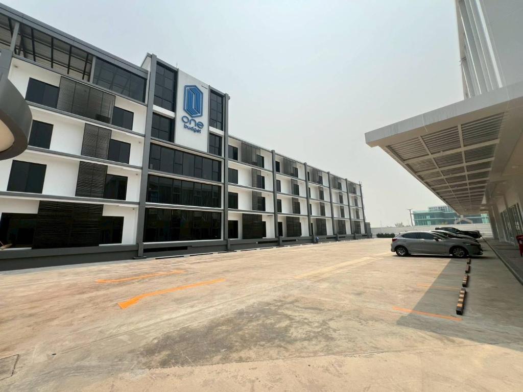 a car parked in a parking lot in front of a building at One Budget Hotel Chiangrai Chiangsaen 2 in Ban Wiang Nuea