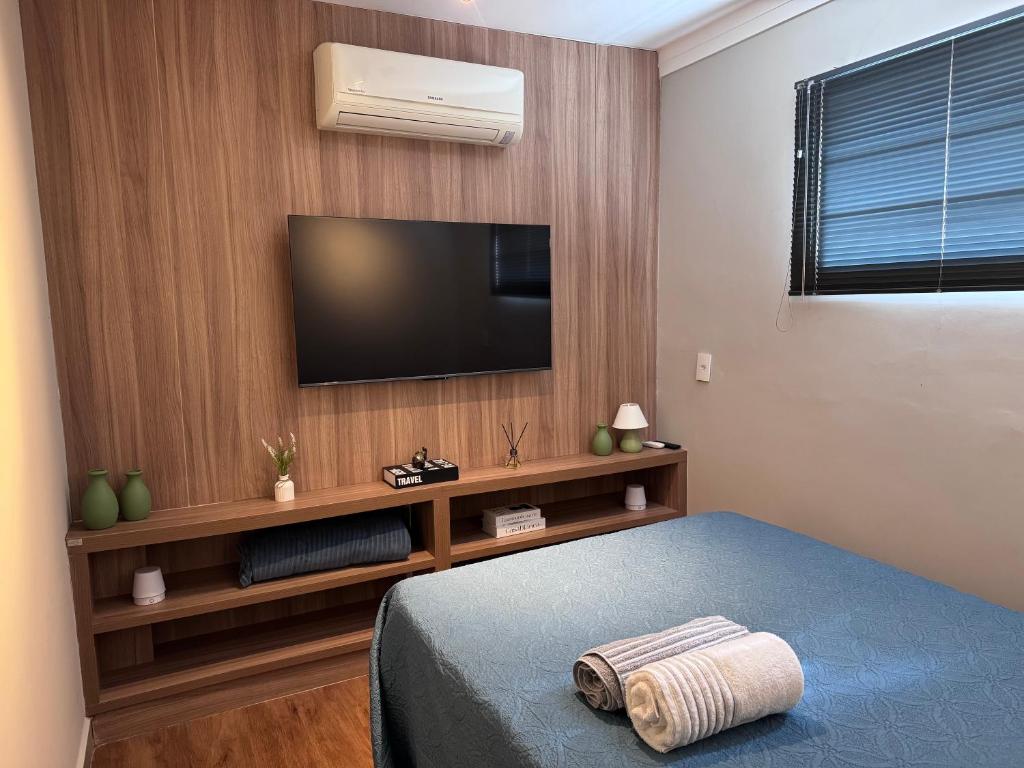 a bedroom with a flat screen tv on a wall at Casa Nova e privativa no Centro de Piracicaba in Piracicaba