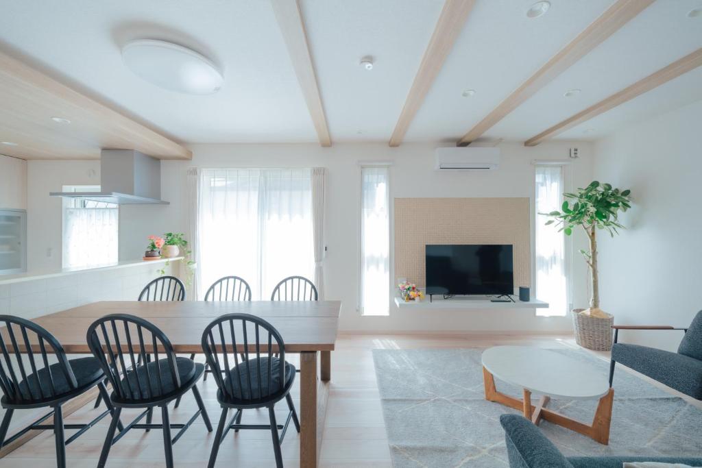 a living room with a table and chairs and a tv at Quiet Japanese House near Airport in Kumamoto