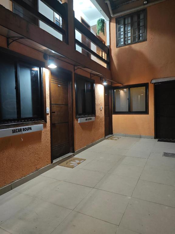 an empty room with doors and windows in a building at Suites Du'Mauro Terreo in Abraão