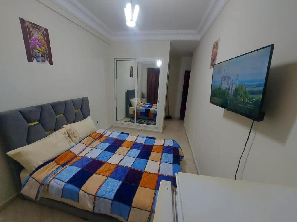a bedroom with a bed and a flat screen tv at Chez alpha in Casablanca