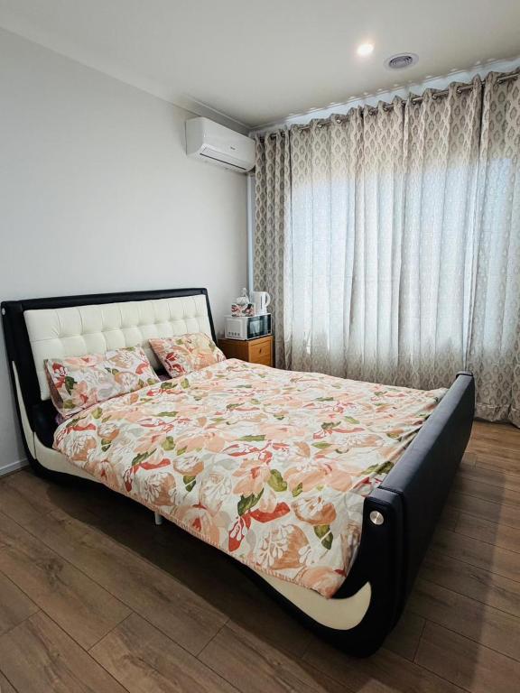 a bedroom with a bed with a floral bedspread at Peaceful Stay in Wyndham Vale