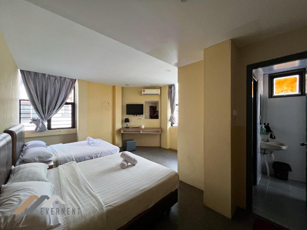 a hotel room with two beds and a sink at Everstay Inn by Evernent in Miri
