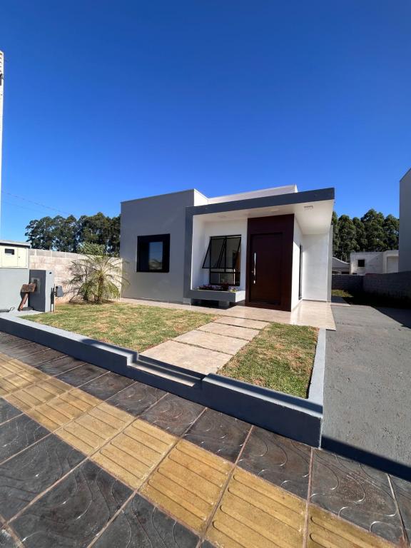 a modern house with a roof at Casa Mobiliada Conforto e Praticidade in Santa Rosa