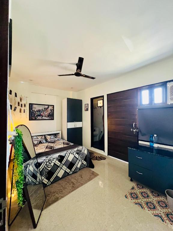 a bedroom with a bed and a ceiling fan at The Cozy Nest in Gurgaon