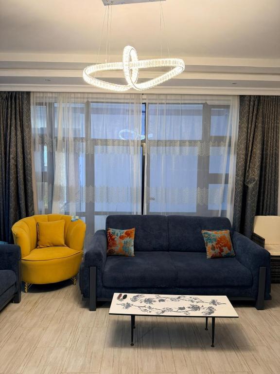 a living room with a blue couch and a yellow chair at Easternville 4 bedroom Maisonette in Nairobi