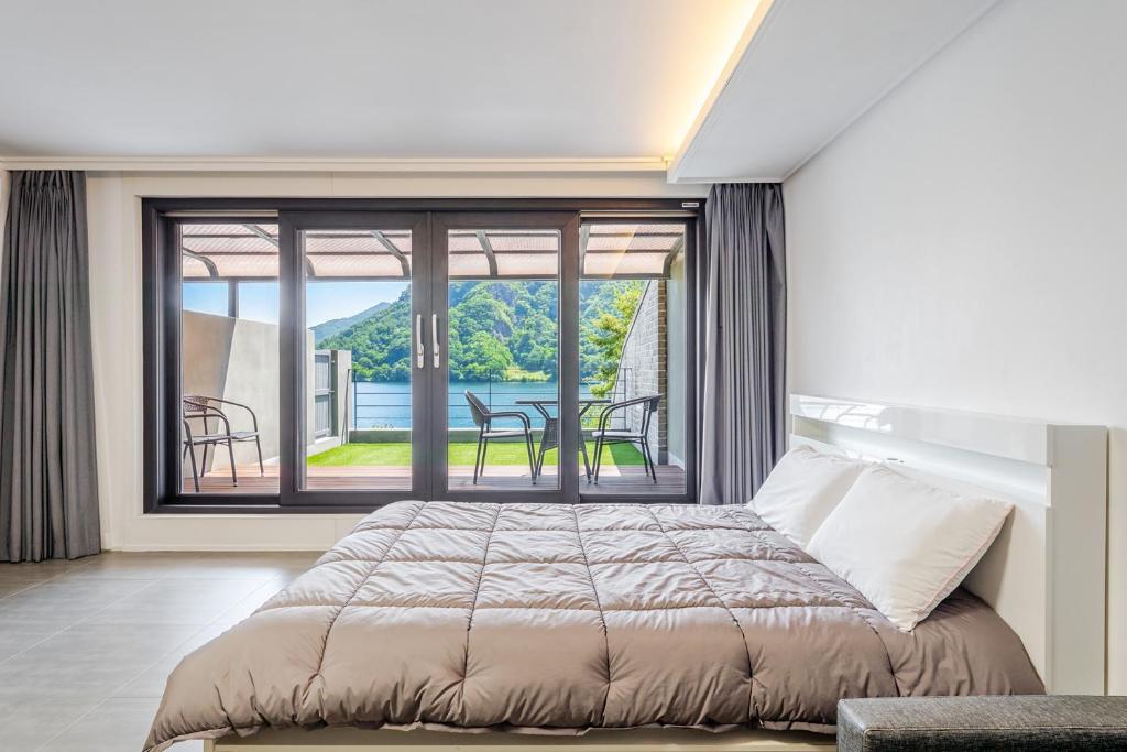 a bedroom with a bed and a large window at Chuncheon Rabbit Star Pension in Chuncheon