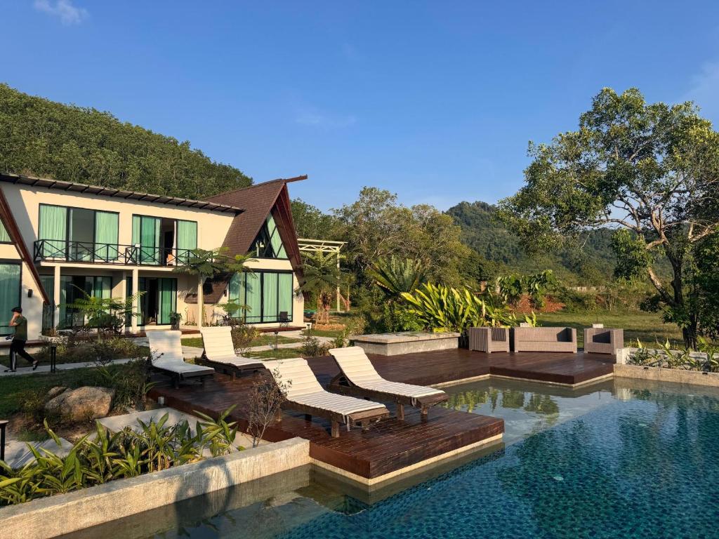 a house with a swimming pool in front of a house at Padé Langkawi in Ulu Melaka