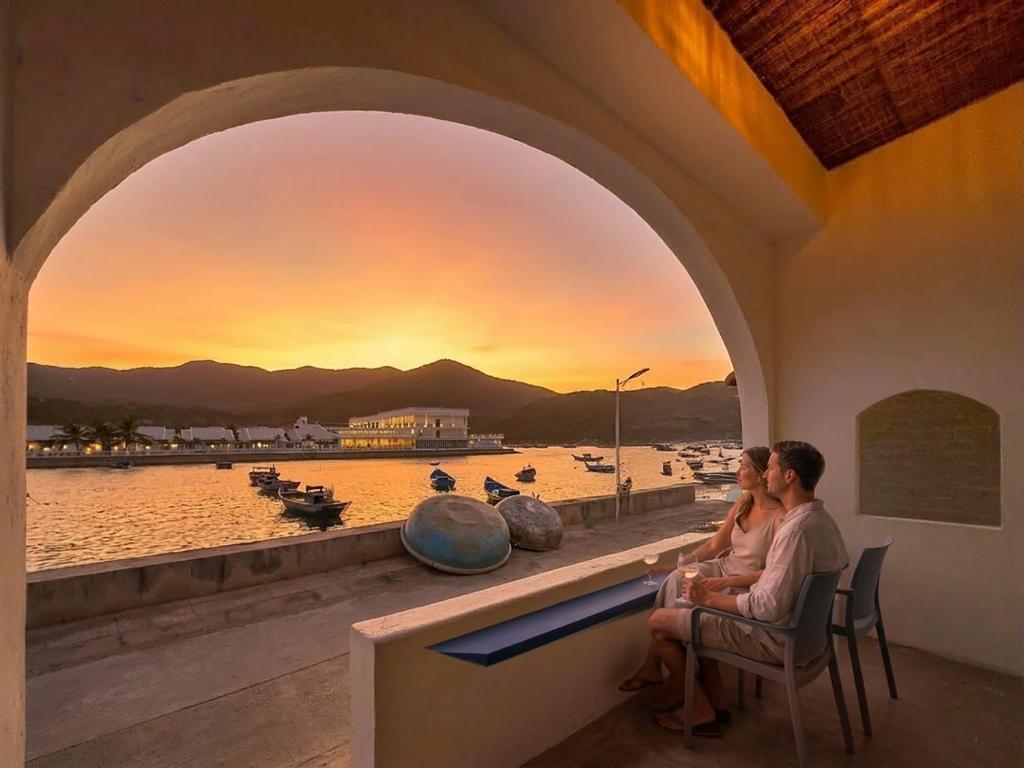 a couple sitting on a bench watching the sunset at O'Stay Vinh Hy in Vĩnh Hy