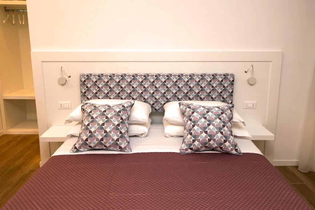 a bed with a headboard and pillows in a room at Dea Guest House in Sorrento